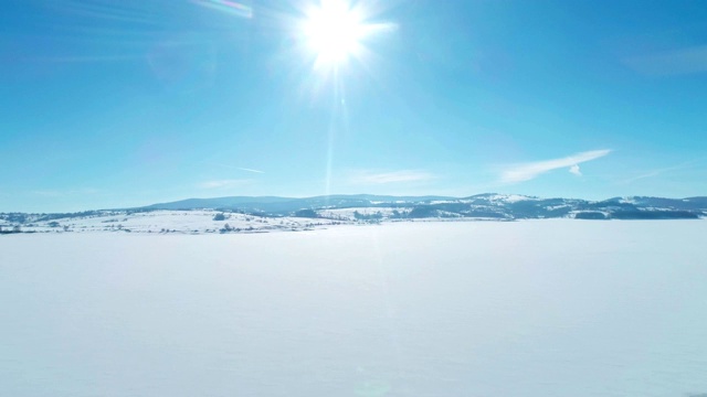 在阳光明媚的冬日里，年轻的女运动员在雪地上跑步。——股票视频视频素材