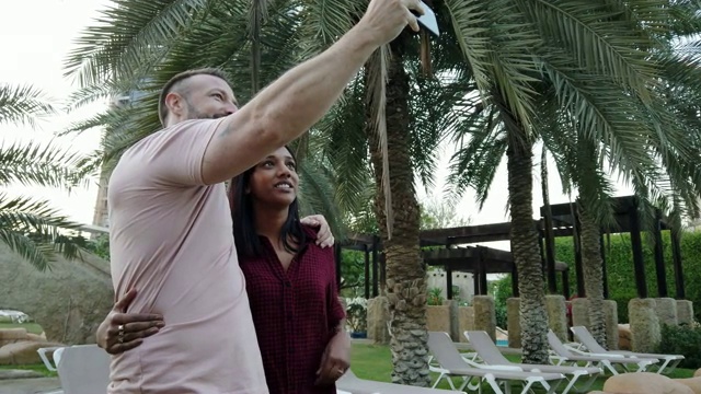 一对正在度假的情侣在智能手机上欣赏一张自拍视频下载