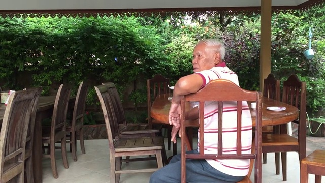 老男人坐在桌子上，在喝茶时间聊天视频素材