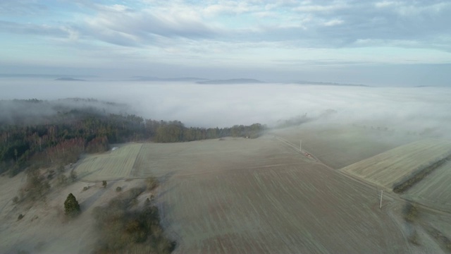 鸟瞰图的雾景观与森林和农田。德国巴伐利亚州弗兰科尼亚的弗兰科尼亚高地。视频素材