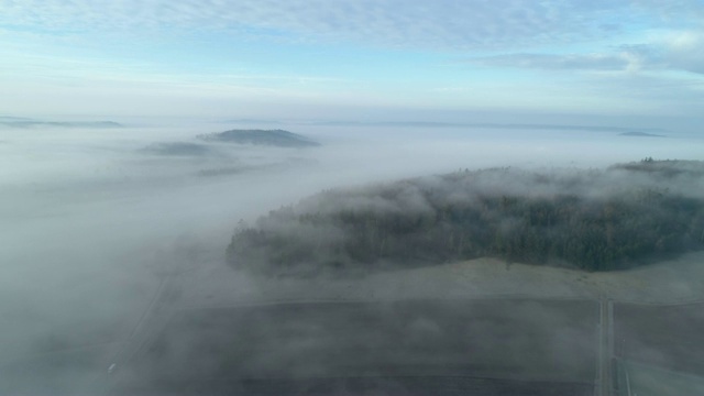 鸟瞰图的雾景观与森林和农田。德国巴伐利亚州弗兰科尼亚的弗兰科尼亚高地。视频素材