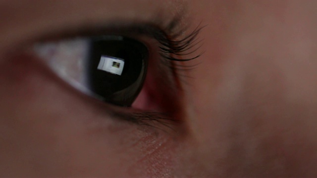 特写镜头的反光笔记本电脑屏幕在女人的眼睛。视频素材