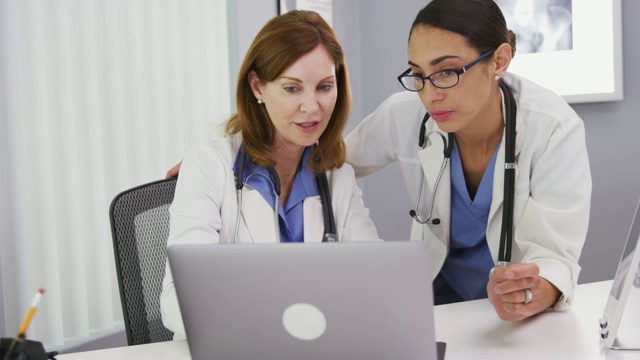 两位医生用笔记本电脑讨论病人的健康状况视频素材
