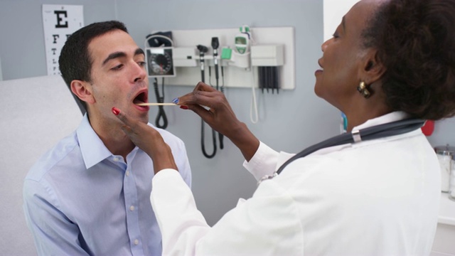 迷人的资深黑人医生检查年轻病人喉咙肿大的疾病视频下载