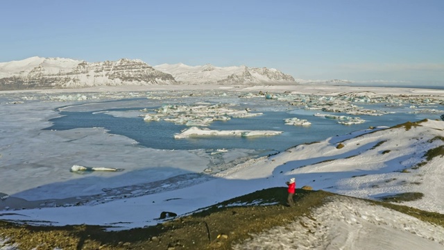 鸟瞰图视频的成熟女人参观Jokulsarlon礁湖，冰岛视频下载