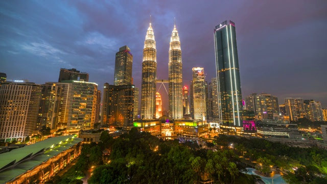 4K时间流逝日落场景的电影移动云和马来西亚吉隆坡市双子星塔视频下载