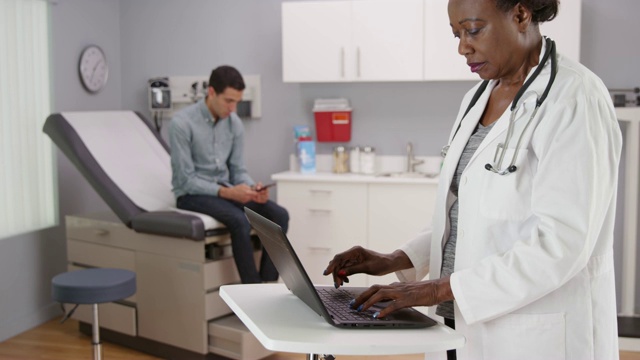 中年非洲女医生在电脑上记录病人的健康状况视频素材