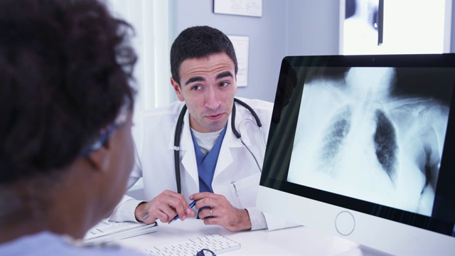 男医生在电脑上显示病人肺部x光片的特写视频下载