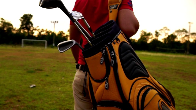 高尔夫球手背着他的高尔夫球袋在高尔夫球场上行走视频下载
