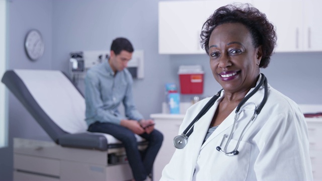 非洲医生的近距离观察镜头，而男性病人等待视频素材