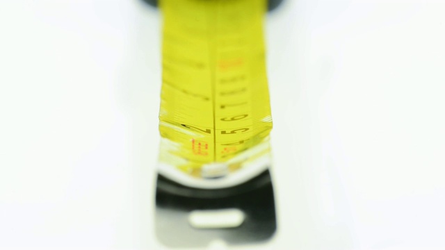一个黄色卷尺的极端特写——用黑色标注英寸和厘米——焦点从1号、2号等移动。视频素材
