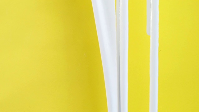 流动的白色油漆在黄色背景高清视频素材
