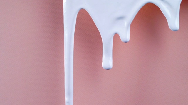 流动的白色油漆在粉红色的背景高清视频素材