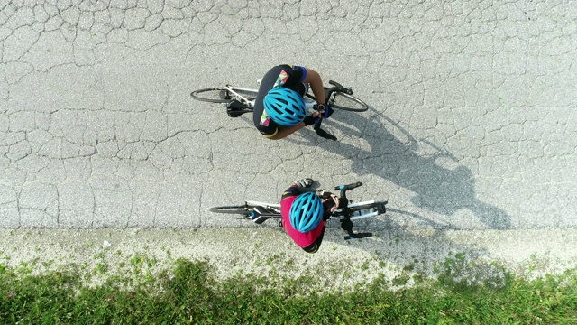 两个骑自行车的人在休息，互相商量着走哪条路视频下载