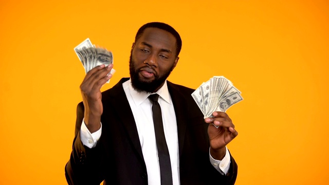 穿着正装的美国黑人男性拿着现金跳舞视频素材