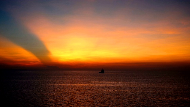 美丽的日落在海上，惊人的颜色，光束通过云景与补给船。视频素材