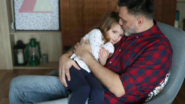 父亲和女儿依偎坐在摇椅上视频素材