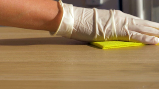给家庭主妇用橡皮手套擦抹布脏桌子用清洁剂视频素材