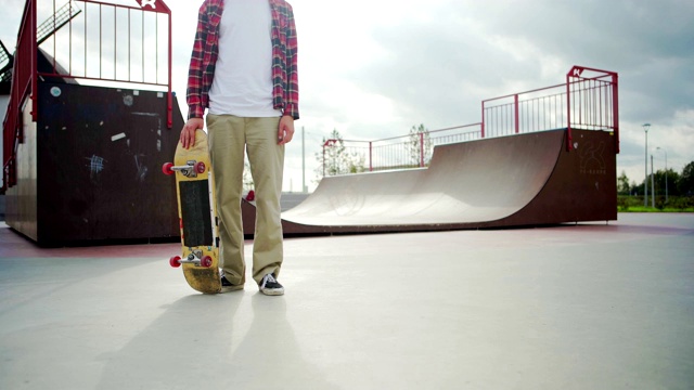 在街头滑板公园的木斜坡周围和摆姿势的家伙滑板的背景视频下载