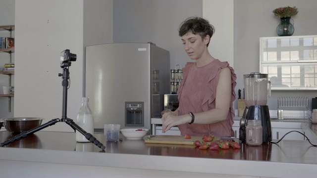 女网红一边切草莓一边拍视频视频素材