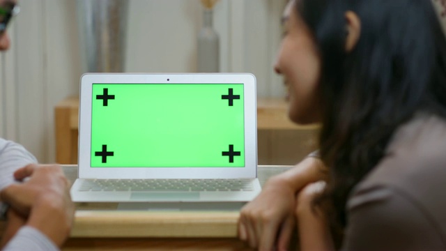 一对情侣相爱的特写在笔记本电脑的绿色屏幕上工作视频素材