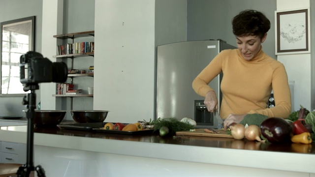 网红在厨房切菜时拍视频视频素材
