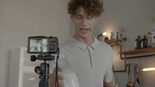 年轻男子制作视频博客，准备用牛奶做甜点视频素材