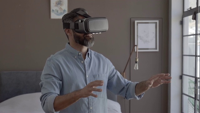 男人在家里的卧室里戴着VR眼镜视频下载