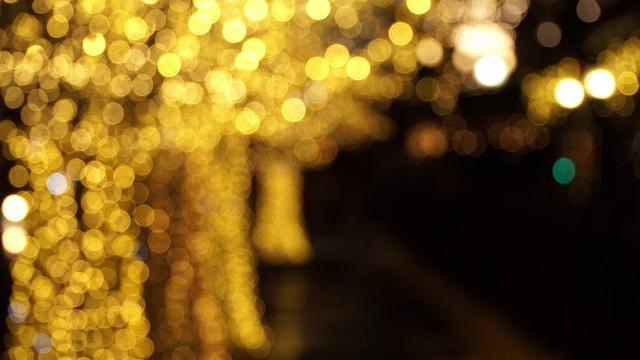模糊的城市街道上的金色花环树。圣诞节和新年假期的背景。视频素材