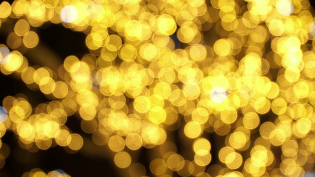 金色的散景模糊了夜街上的花环。圣诞节和新年假期的背景视频素材