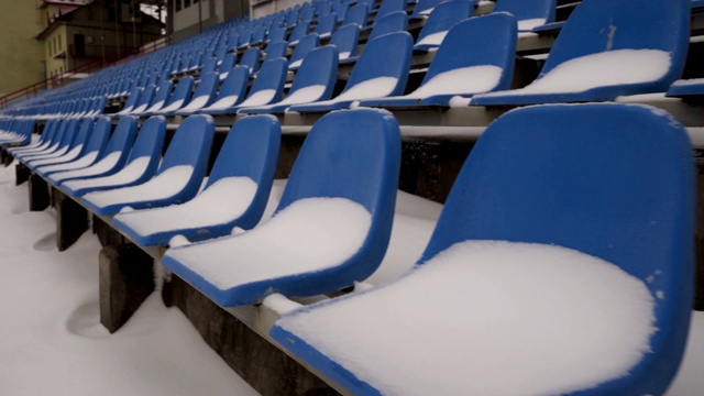 冬季，体育场空空如也的座椅上覆盖着积雪视频素材