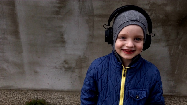 男孩戴着无线耳机在街上听音乐视频素材