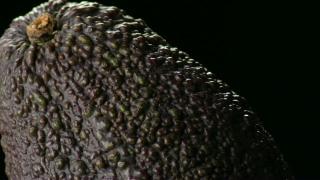 成熟的牛油果皮与黑色背景旋转视频下载
