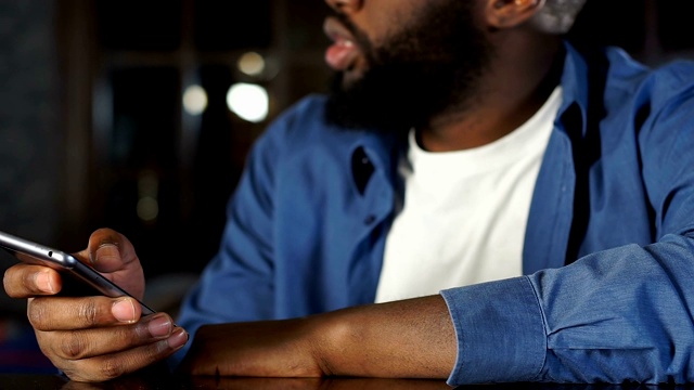 非裔美国人在用手机应用与酒吧游客交流，预订出租车视频下载