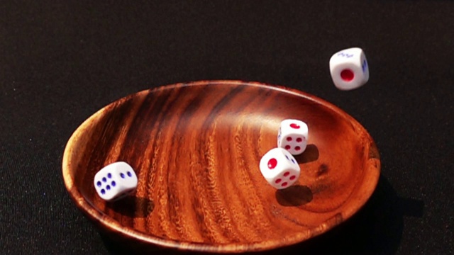 骰子落在木碗中的特写镜头，背景为黑色视频素材