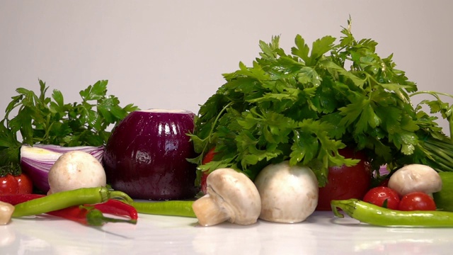 在白色的背景上，新鲜的蔬菜和水一起慢慢落下视频素材