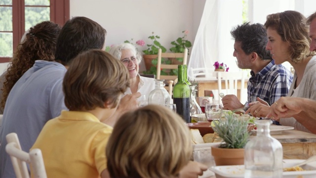 快乐的高级妇女享受与家人在餐桌上视频素材
