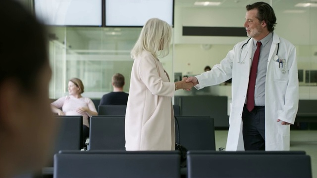 医生在候诊室和一位女士握手视频下载