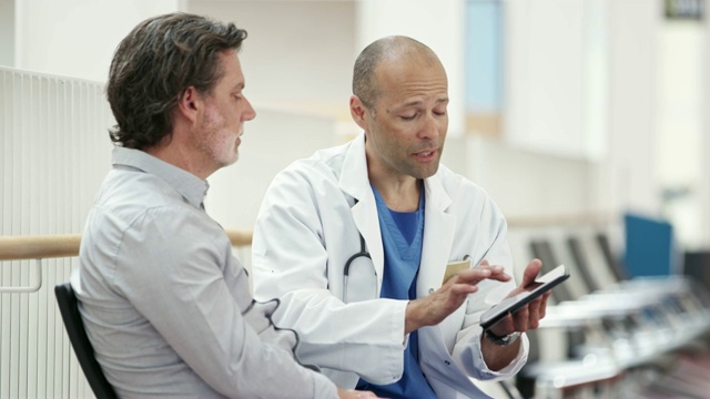 成熟的医生向病人展示数字平板电脑视频素材