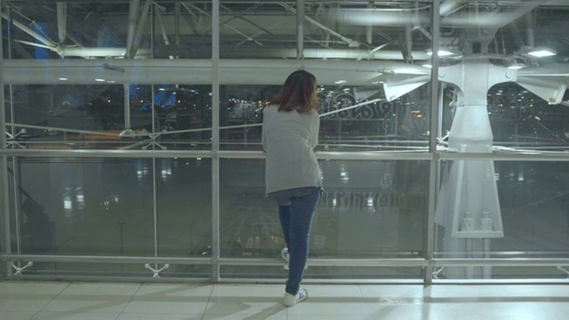 年轻的亚洲背包女在国际机场四处张望。视频素材