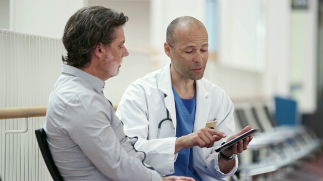 医生向男病人展示平板电脑视频素材
