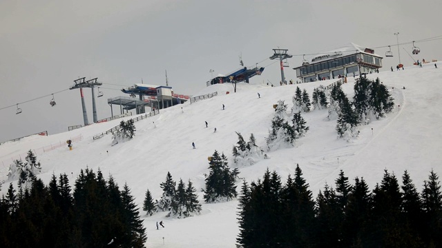 冬季滑雪场，滑雪缆车和人们在滑雪坡道上视频素材