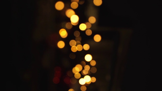 摘要圣诞金景在夜里，镜头在移动。圣诞节和新年假期的背景。视频素材