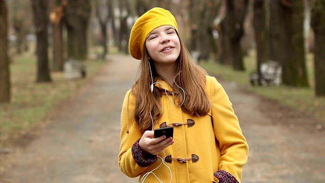 快乐的少女用智能手机听音乐视频素材