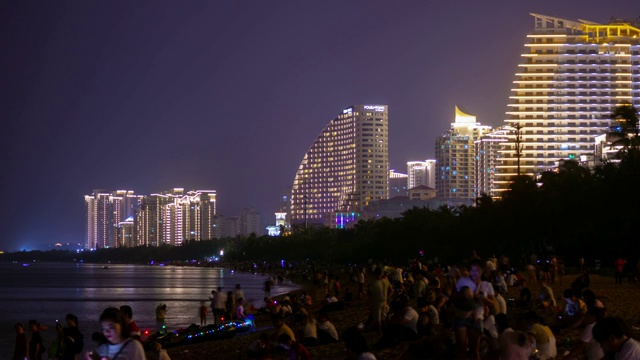 夜光照耀三亚拥挤的海滩海岸线酒店全景4k时间推移海南岛中国视频素材