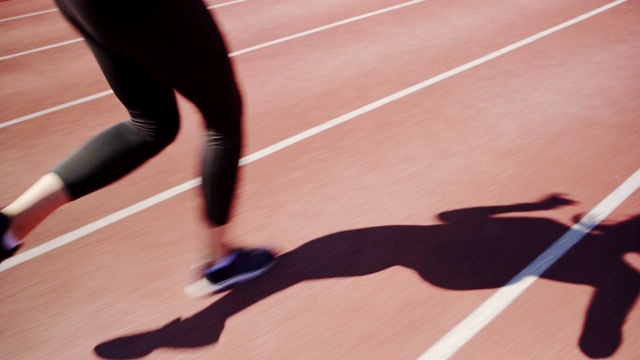 跟踪镜头，一个不认识的女人在跑道上短跑视频下载