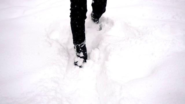 脚到全身跟踪云台拍摄-年轻的亚洲男子挣扎着走在公园的深雪视频素材