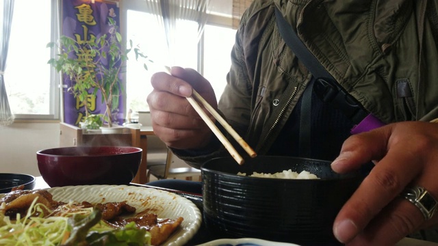 一名男子在日本餐馆用筷子吃日本料理套餐视频下载