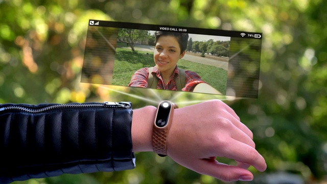 女运动员手唤全息图中出现的朋友。智能手表未来和科技。背景是绿树。视频下载