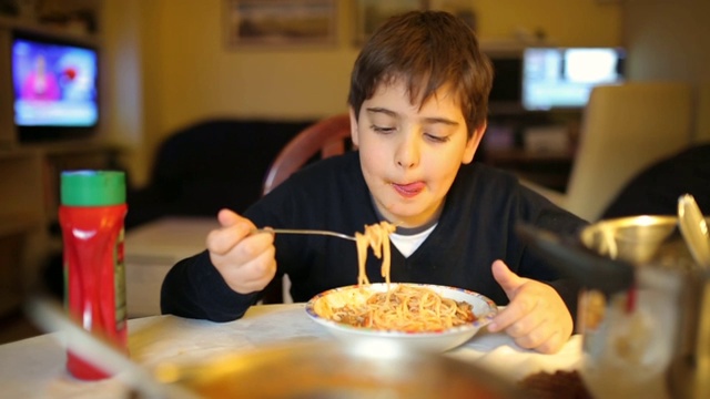 可爱的小学生在餐厅吃意大利面当晚餐视频下载